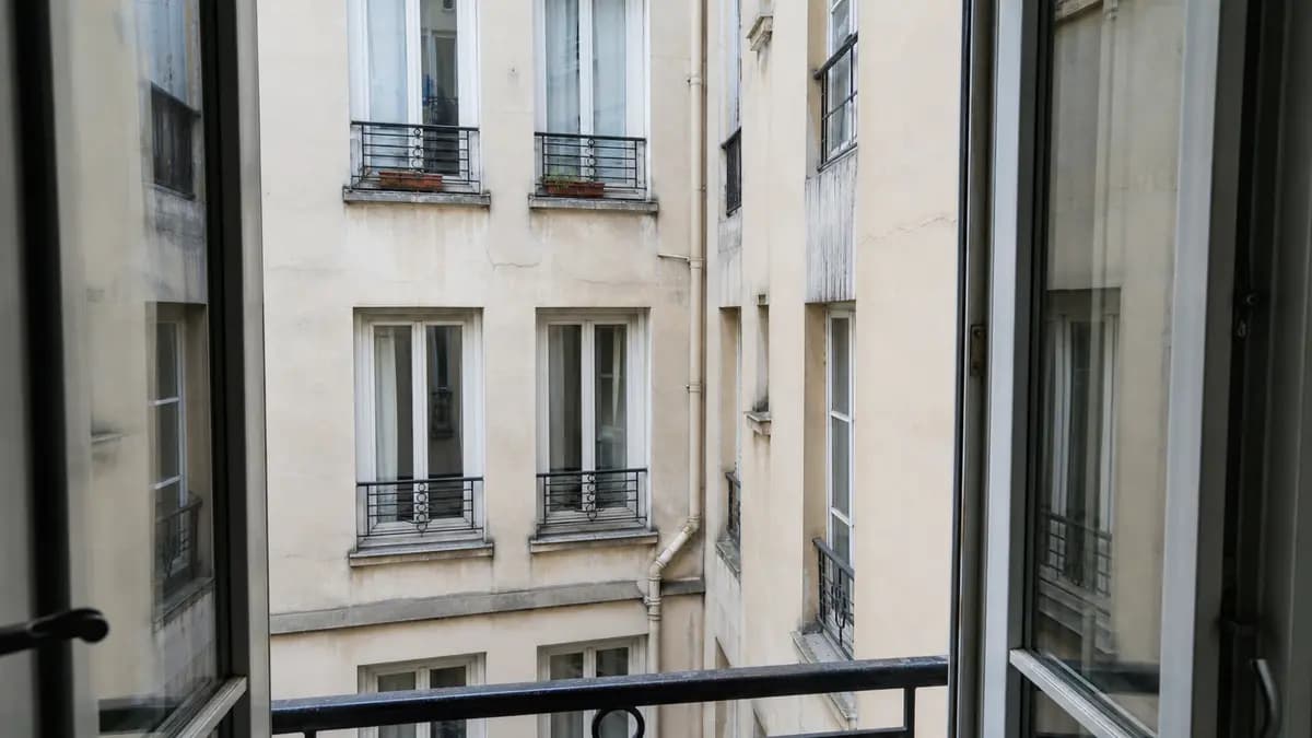 Vis-à-vis depuis une fenêtre sur cour intérieure parisienne